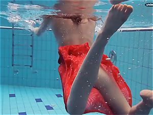 crimson clothed teen swimming with her eyes opened